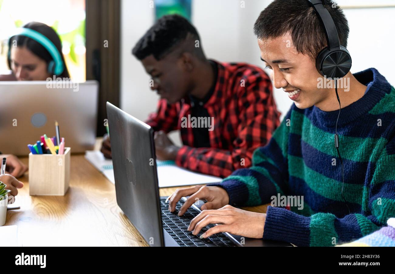 Jeunes étudiants multiraciaux à la maison travaillant ensemble sur le projet scolaire - concept d'éducation Banque D'Images