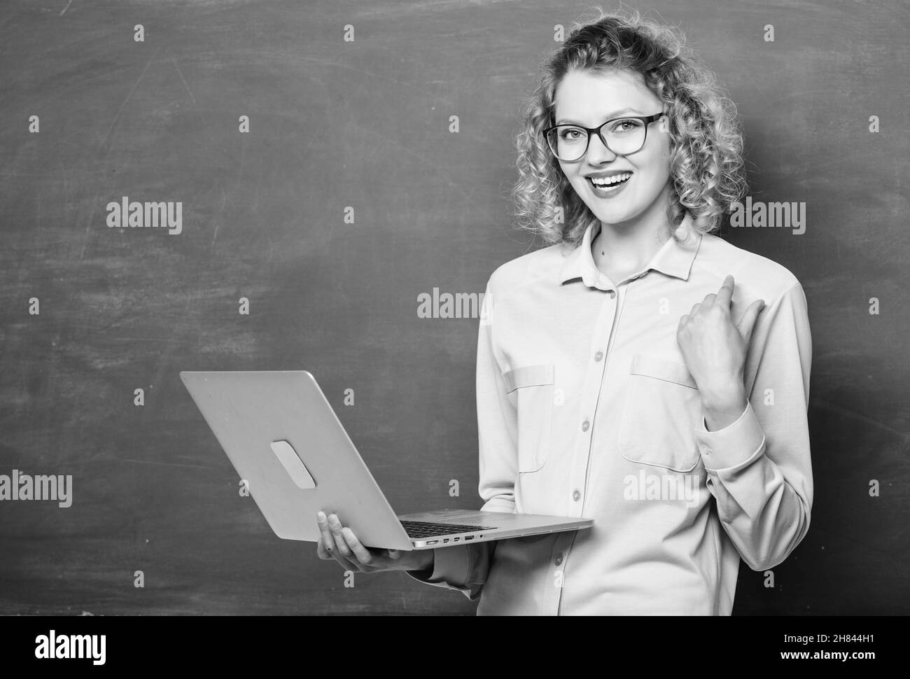 Cours en ligne d'enseignement. Concept de scolarisation en ligne. Carnet de notes de l'enseignant recherche informations fond du tableau de surveillance. École en ligne. Femme surfant sur un ordinateur portable Banque D'Images