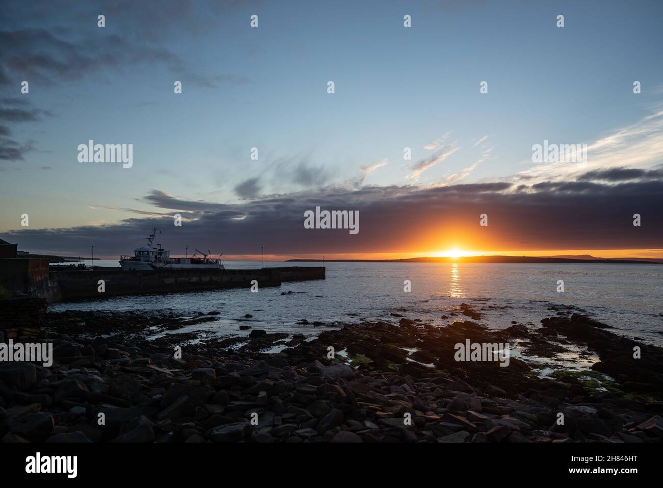 La vue sur la mer comme le soleil coule sous les nuages et l'horizon lointain à la fin de la journée à John O Groats. Banque D'Images