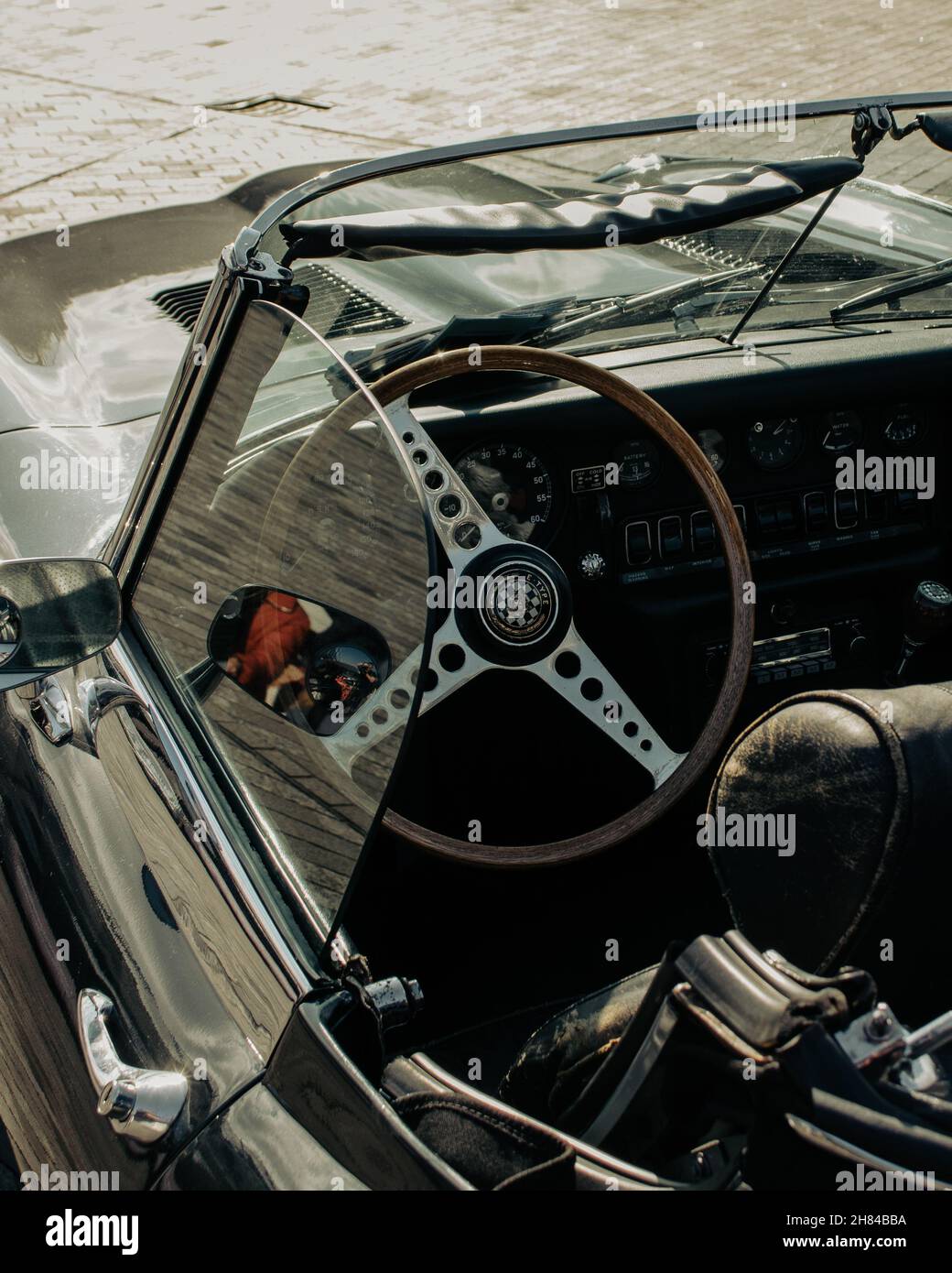 Une photo en grand angle de l'intérieur d'une voiture classique décapotable verte prise par une journée ensoleillée. Banque D'Images