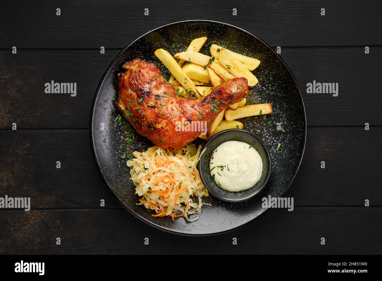 Vue de dessus de la cuisse de poulet cuite avec des frites américaines et du chou mariné sur une assiette Banque D'Images