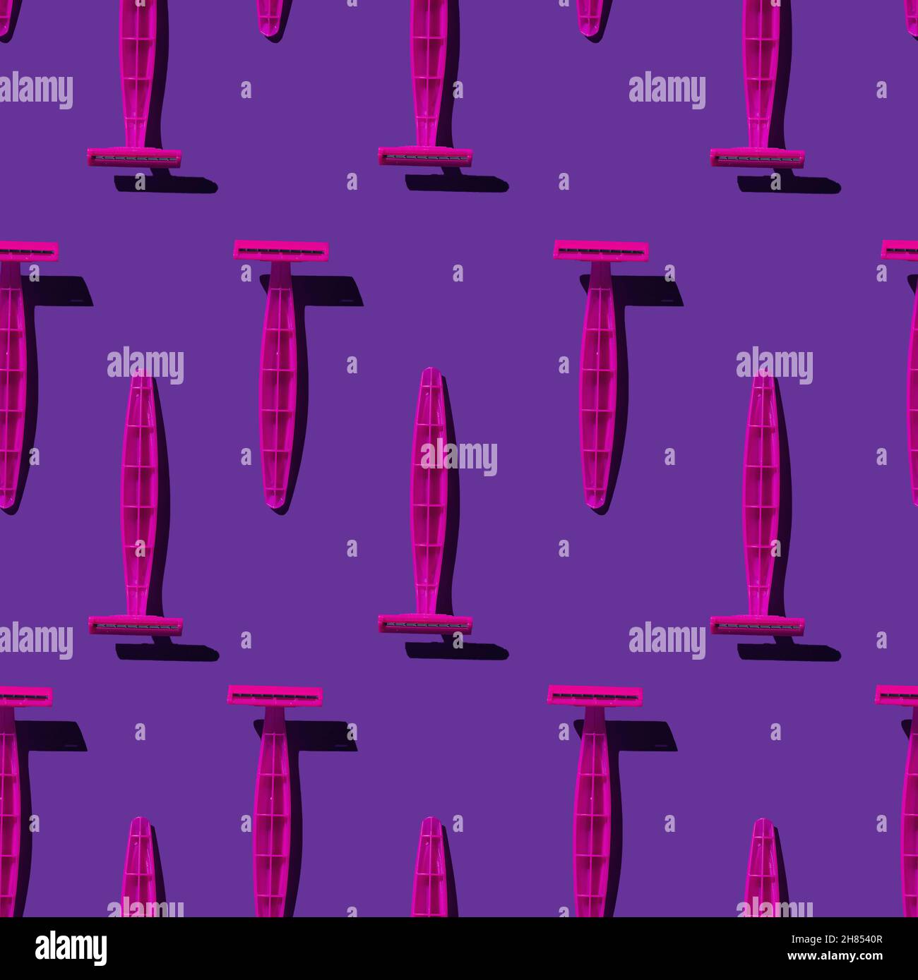Un groupe de rasoirs en plastique rose.Motif sans couture.Rasoirs rose vif sur fond violet vif.Prise de vue avec une lumière intense et des ombres noires dures. Banque D'Images