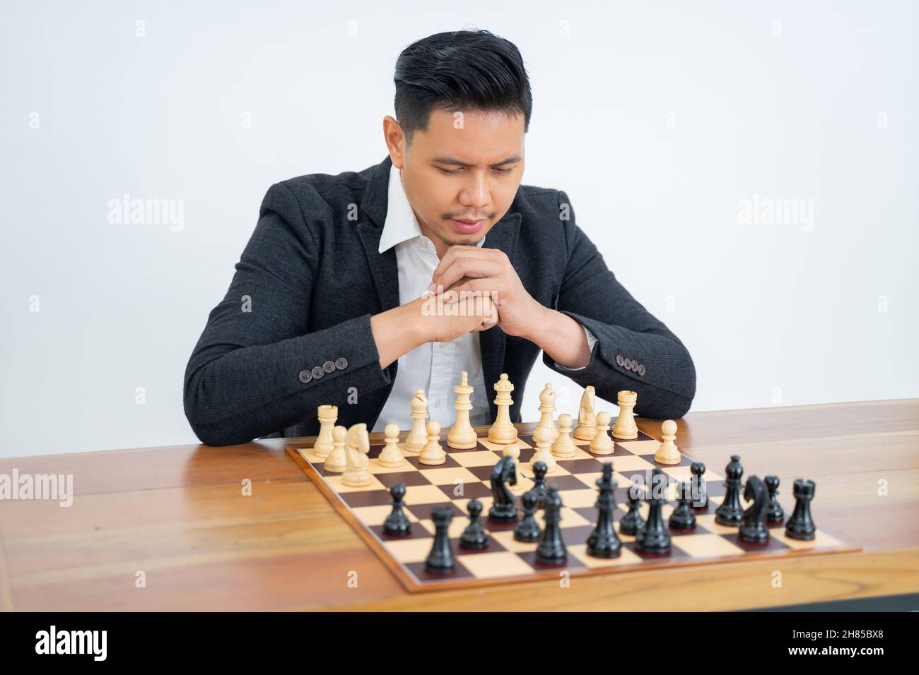 Homme avec une expression profonde de pensée courir des étapes tout en jouant aux échecs Banque D'Images