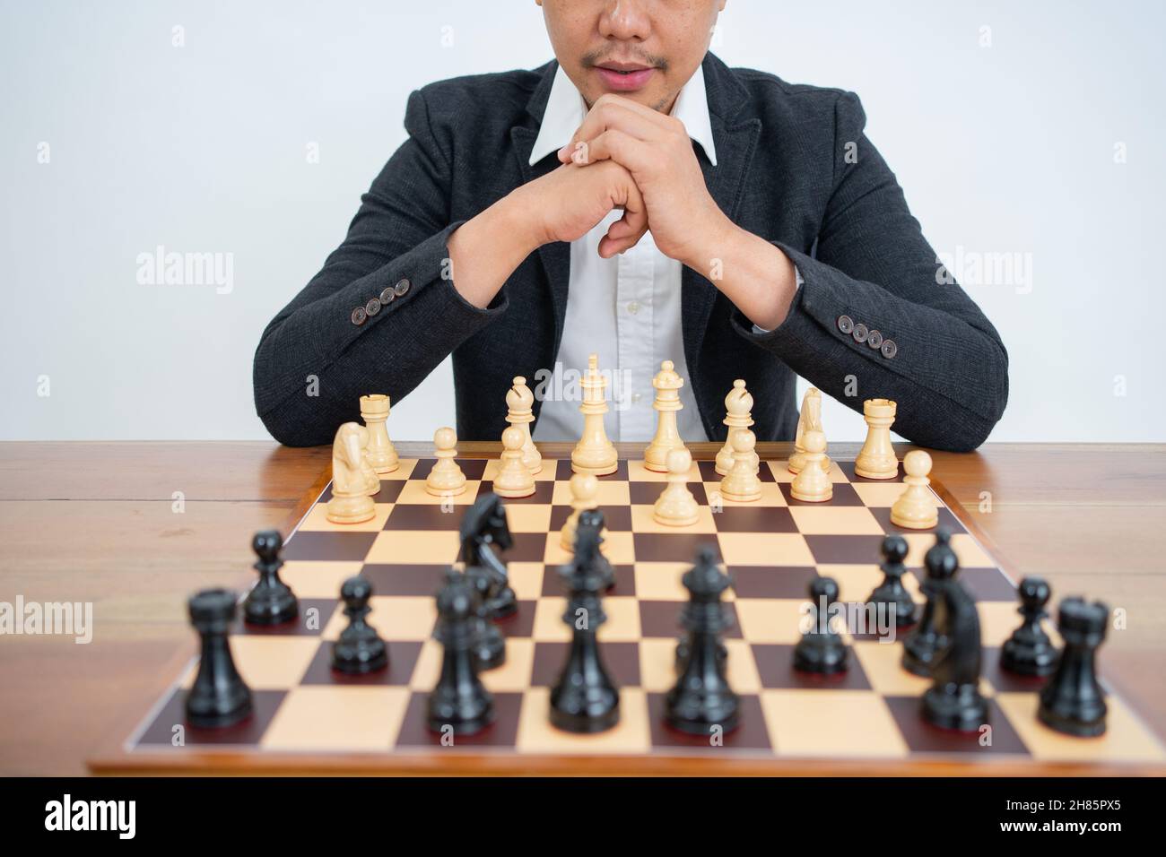 Pièces d'échecs sur un échiquier avec un maître jouant aux échecs Banque D'Images