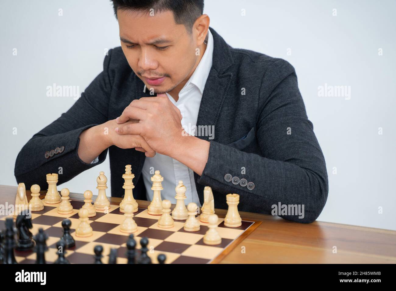 L'homme se concentre sur la prise de pas tout en jouant aux échecs Banque D'Images