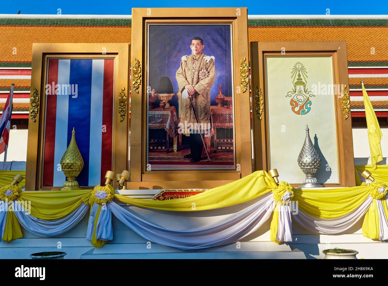 Portrait du roi thaïlandais Maha Vajiralongkorn, drapeau thaïlandais (l) et emblème royal à l'extérieur (temple) de Wat po, Bangkok, Thaïlande Banque D'Images