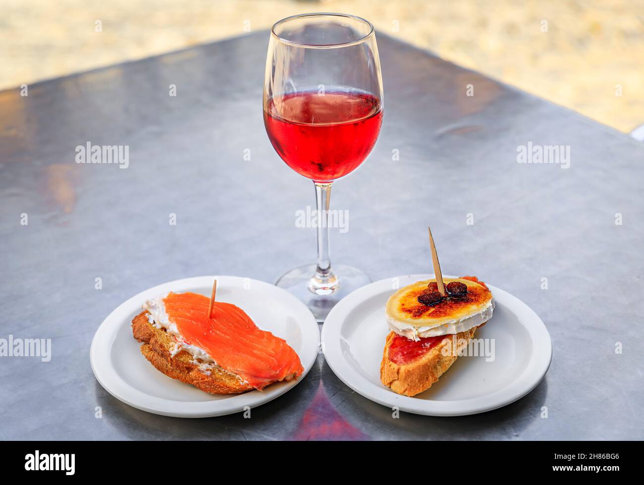 Tostadas au saumon et au crabe et au fromage au four pintxos ou tapas avec un verre de rose espagnole ou de vin de rosado dans un café dans la ville médiévale d'Olite, en Espagne Banque D'Images