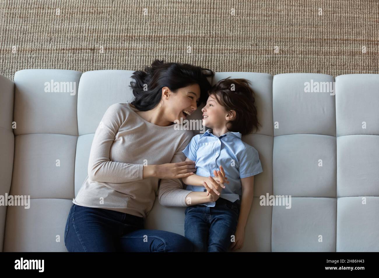 Au-dessus de la vue riant maman et fils allongé sur le canapé Banque D'Images