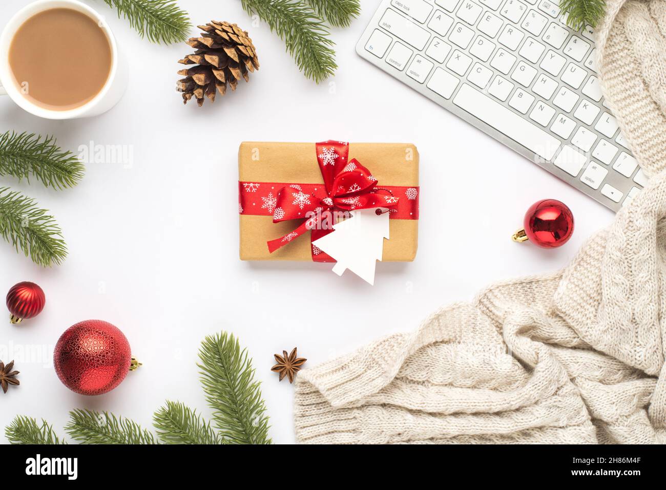 Vue du dessus photo de clavier tasse de hot buvant rouge arbre boules de noël brindilles pin cône anis confortable chandail et boîte-cadeau avec étiquette en forme de sapin sur isolé Banque D'Images
