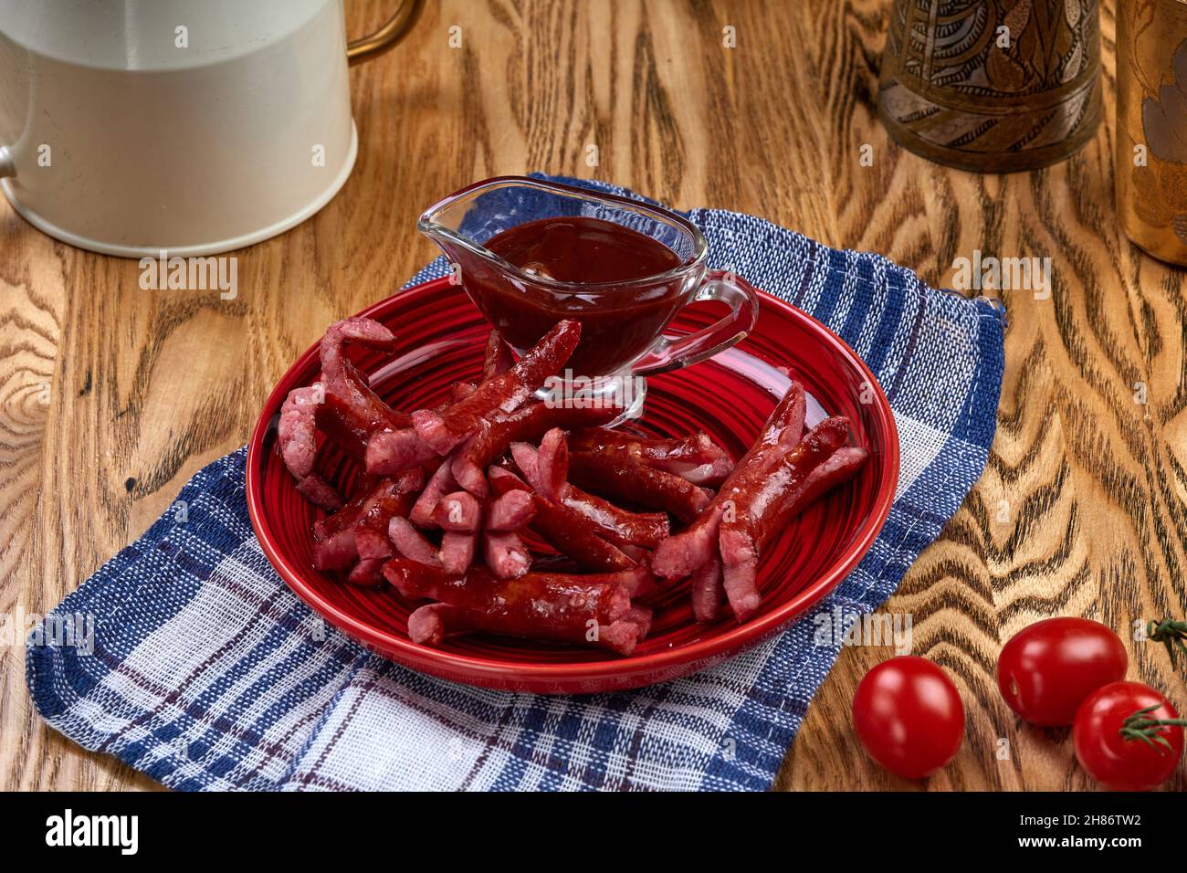 Saucisses frites sur une assiette rouge sur une table en bois Banque D'Images