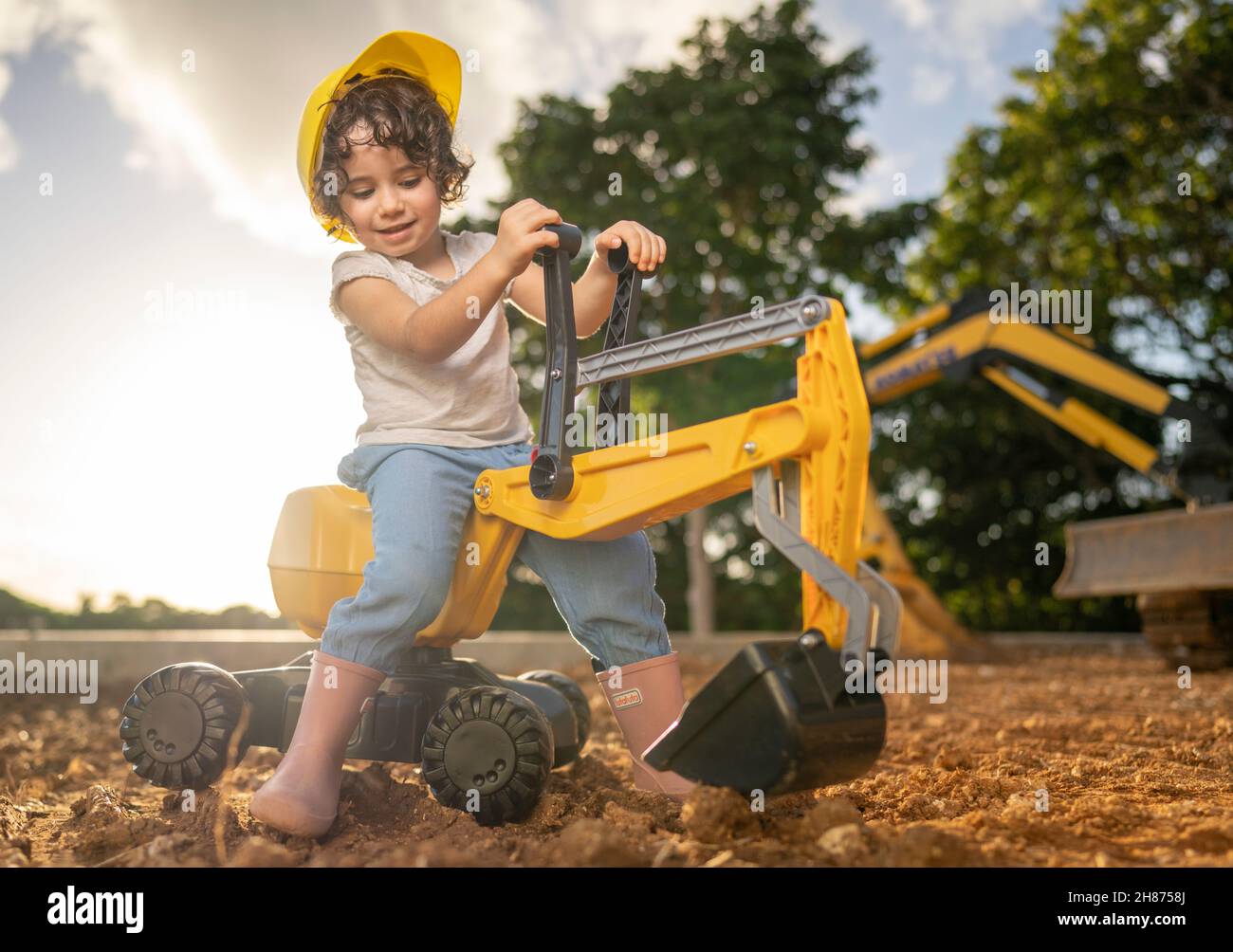 une jeune fille de 3 ans joue avec un jouet de digger Banque D'Images