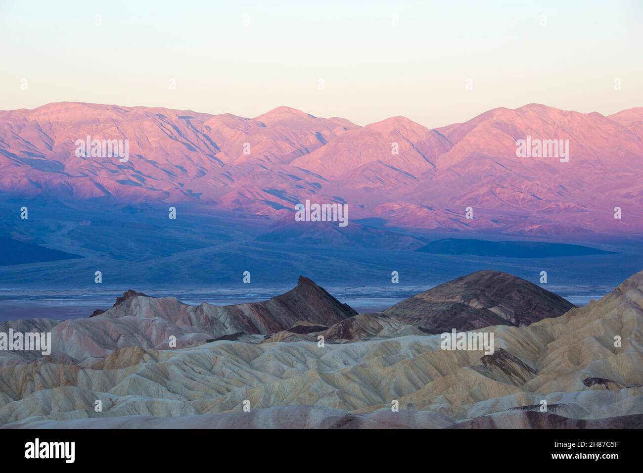 Parc national de Death Valley, Californie, États-Unis.Vue de Zabriskie point à travers le paysage aride du désert jusqu'à la chaîne Panamint, lever du soleil. Banque D'Images