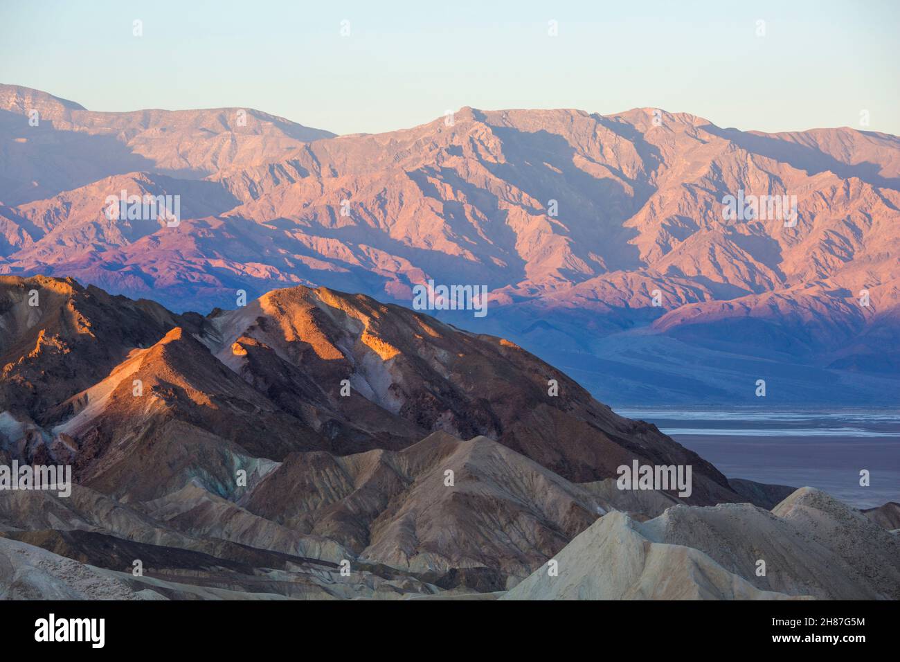 Parc national de Death Valley, Californie, États-Unis.Vue de Zabriskie point à travers le paysage aride du désert jusqu'à la chaîne Panamint, lever du soleil. Banque D'Images