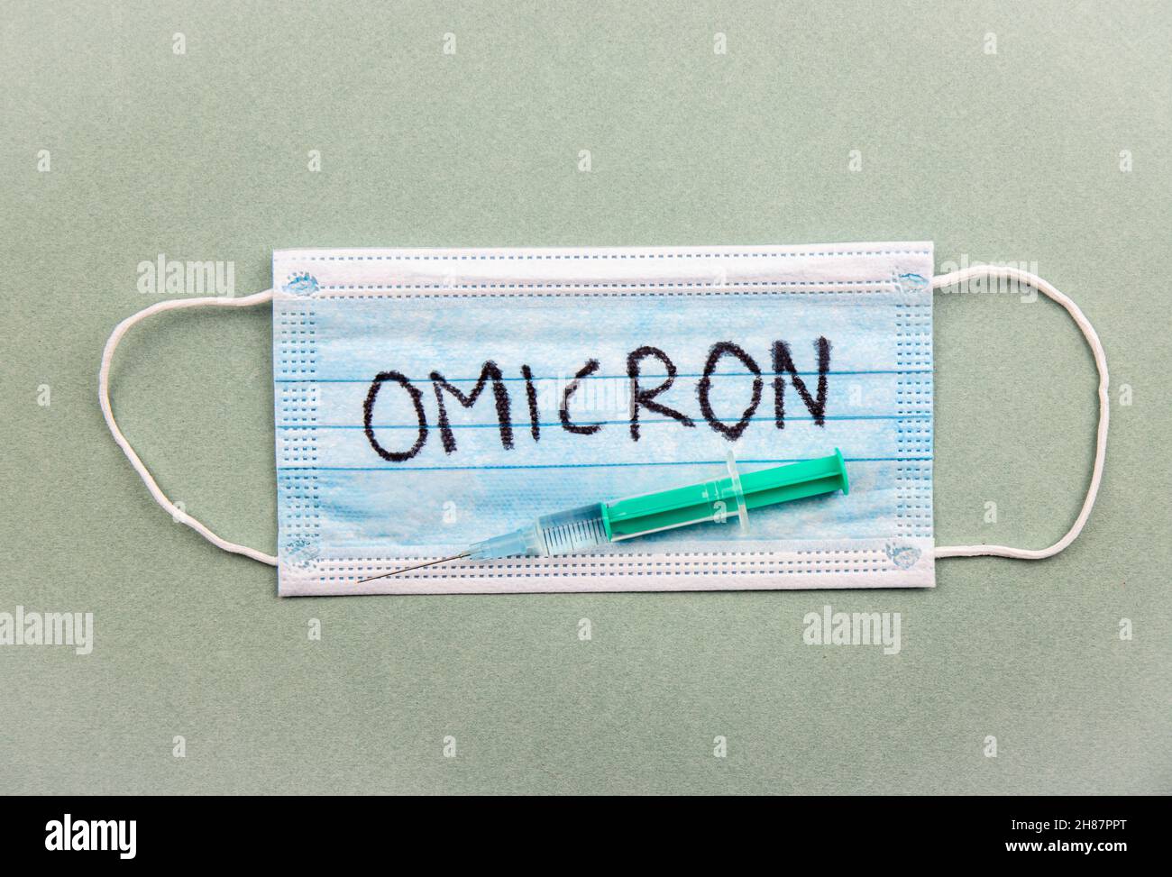 Nouveau coronavirus mutation Covid-19 concept Omicron.Masque médical, seringue et texte avec lettres Omicron. Banque D'Images