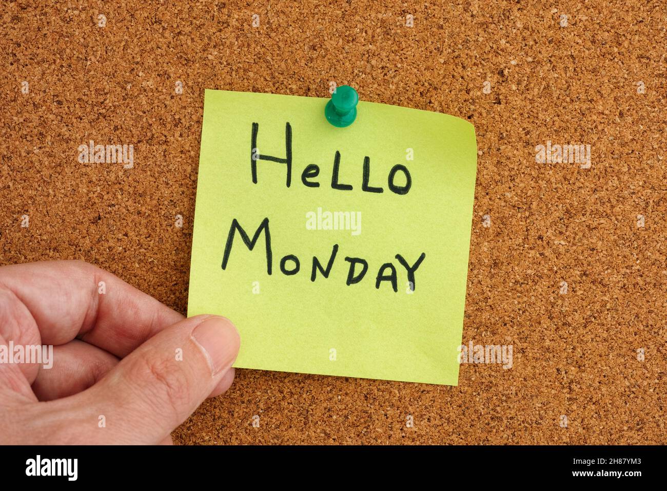Un homme tenant une note collante qui est accroché à un tableau de bord avec le salut lundi sur lui.Gros plan. Banque D'Images