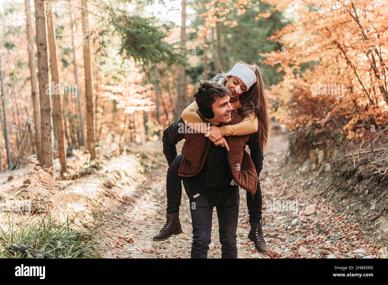 Jeune couple romantique dans les bois.Promenade en pigeyback.Heureux ensemble Banque D'Images