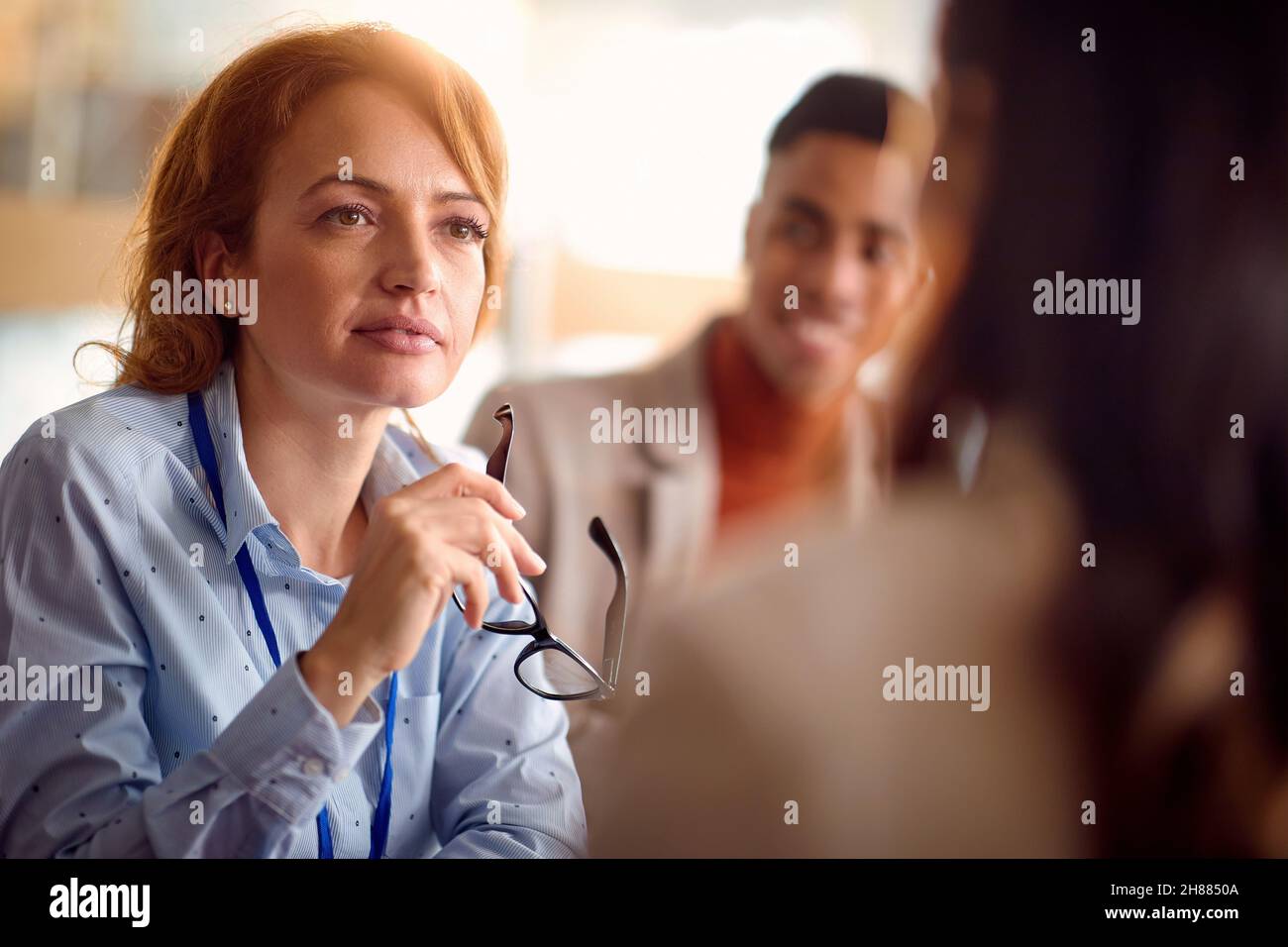 Femme souriante discussion informelle avec des collègues Banque D'Images