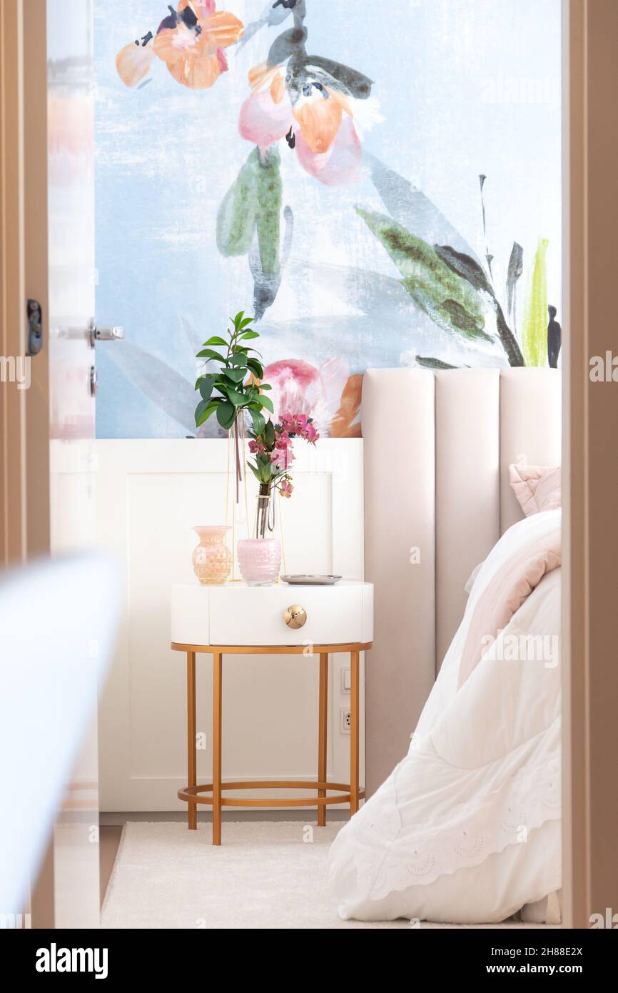 Photographie intérieure montrant le couloir de l'appartement avec table de chevet et papier peint tropical coloré. Banque D'Images