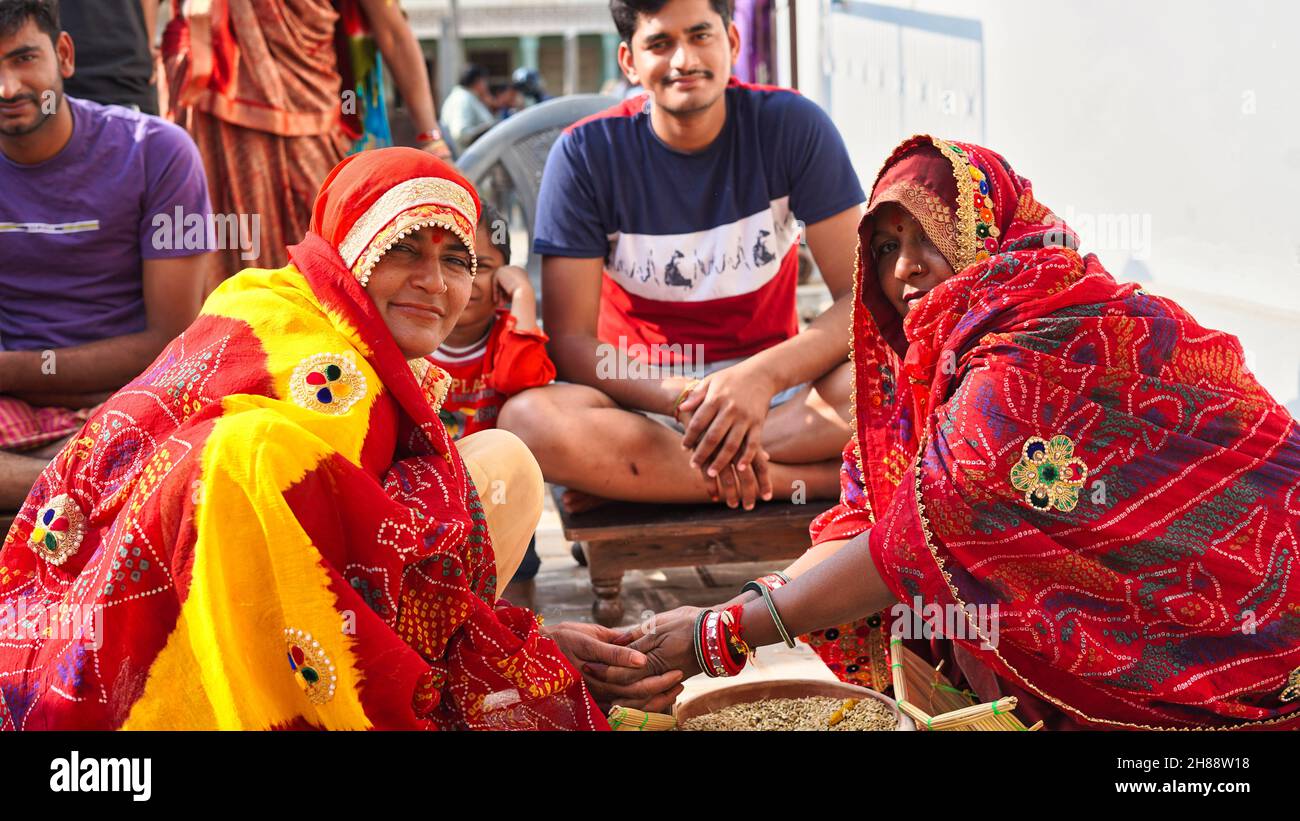 21 novembre 2021 Reengus, Rajasthan, Inde.Les femmes indiennes célèbrent le mariage de travail heureux assis devant le marié. Banque D'Images