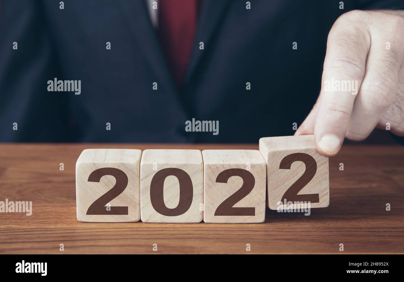 Nouveau concept d'année d'un homme d'affaires changeant un calendrier à l'année 2022 Banque D'Images