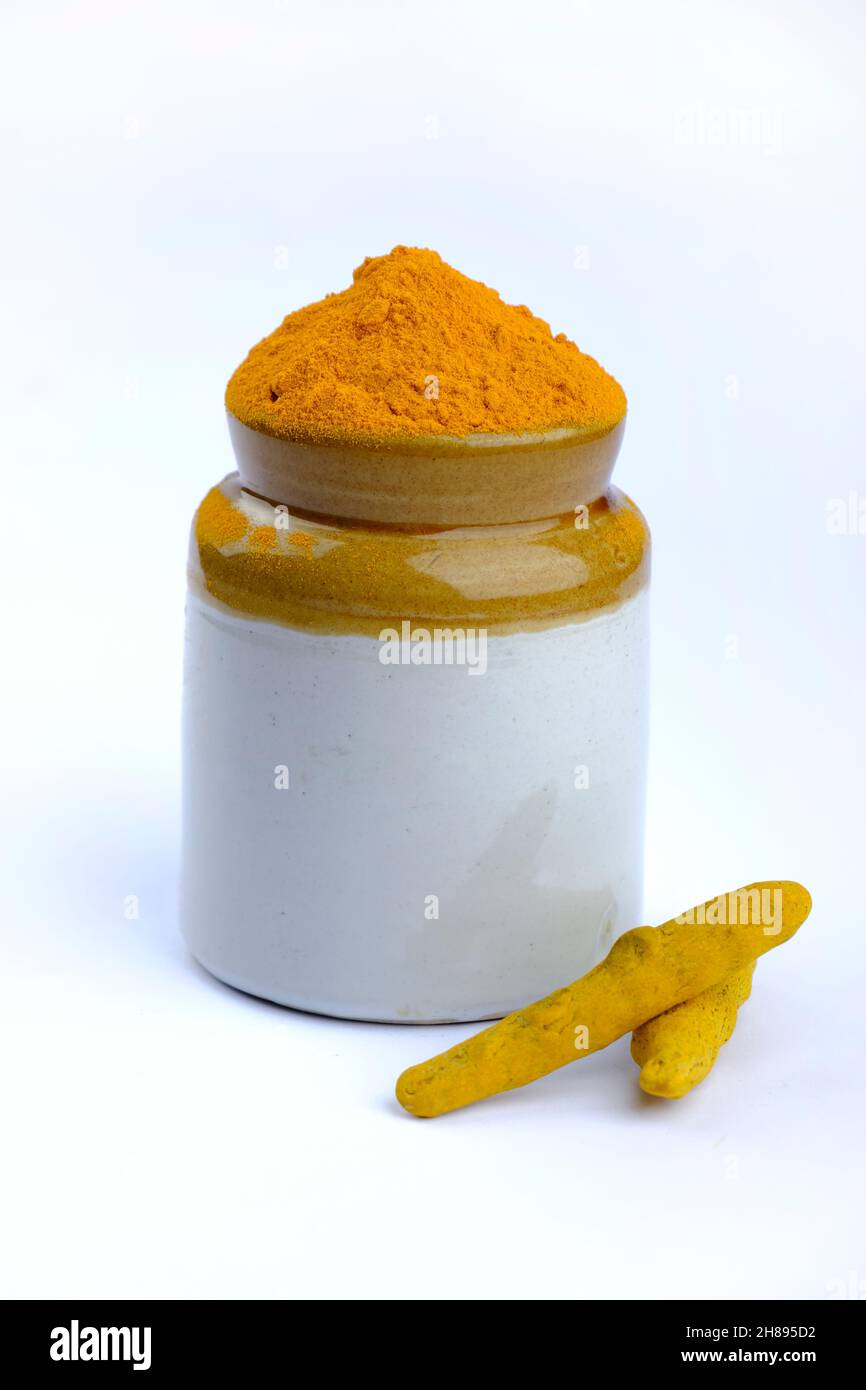 Poudre de curcumine, poudre de curcumine dans un bol à côté des racines de curcuma et poudre de curcuma dispersée sur une surface, isolée sur fond blanc. Banque D'Images