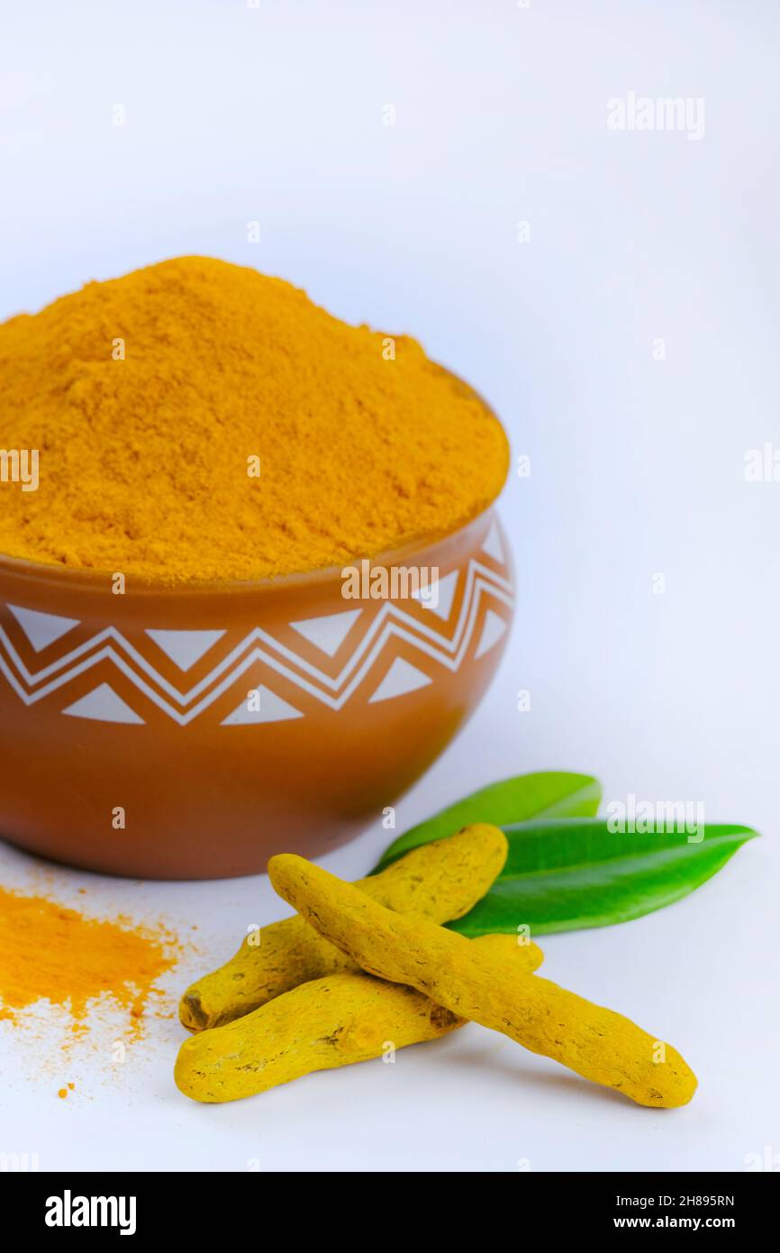 Poudre de curcumine, poudre de curcumine dans un bol à côté des racines de curcuma et poudre de curcuma dispersée sur une surface, isolée sur fond blanc. Banque D'Images