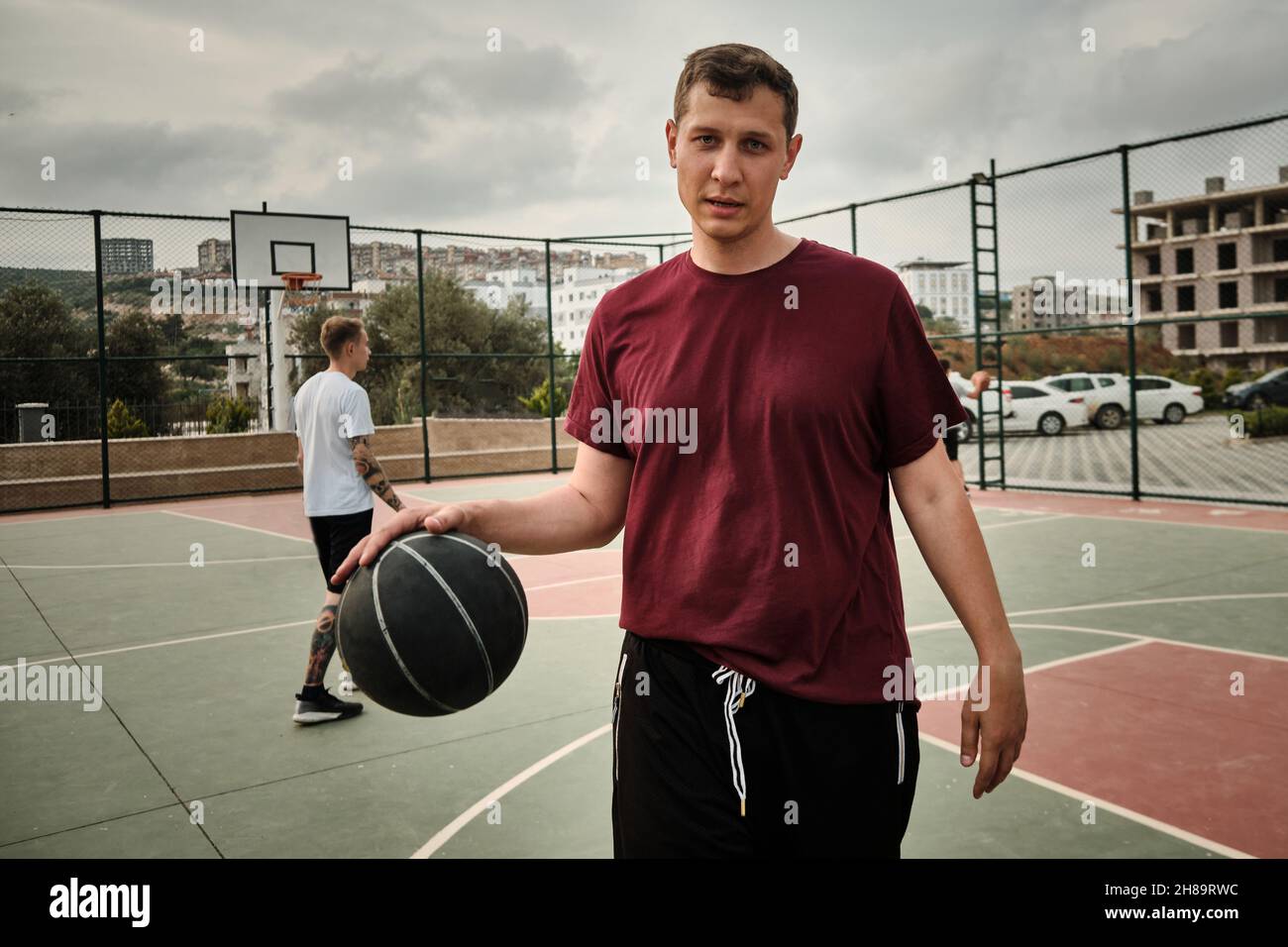 L'homme joue au basket-ball sur le terrain extérieur Banque D'Images