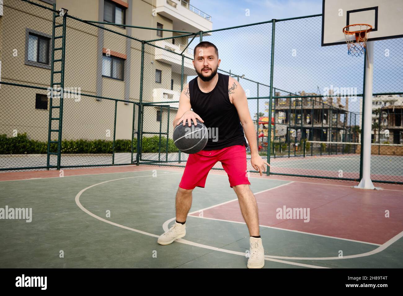 L'homme joue au basket-ball sur le terrain extérieur Banque D'Images