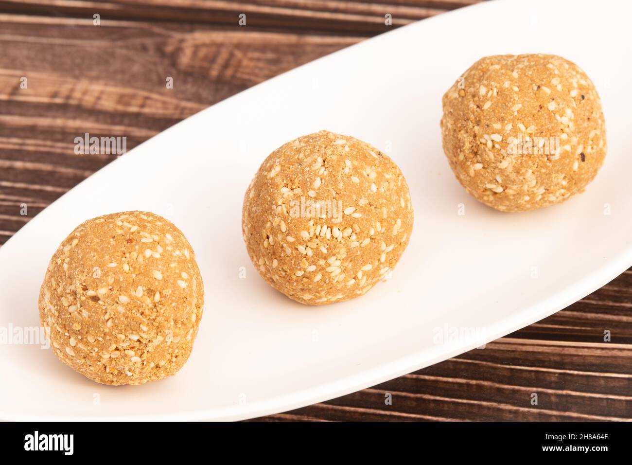 Le Mithai indien connu sous le nom de Tilgul Ladoo, Gajak Laddu, Gajjak Laddoo, Gazak ou Gachak est fait de graines de sésame Til, Gur ou Gard mélangé avec le Mugfali rôti, K Banque D'Images