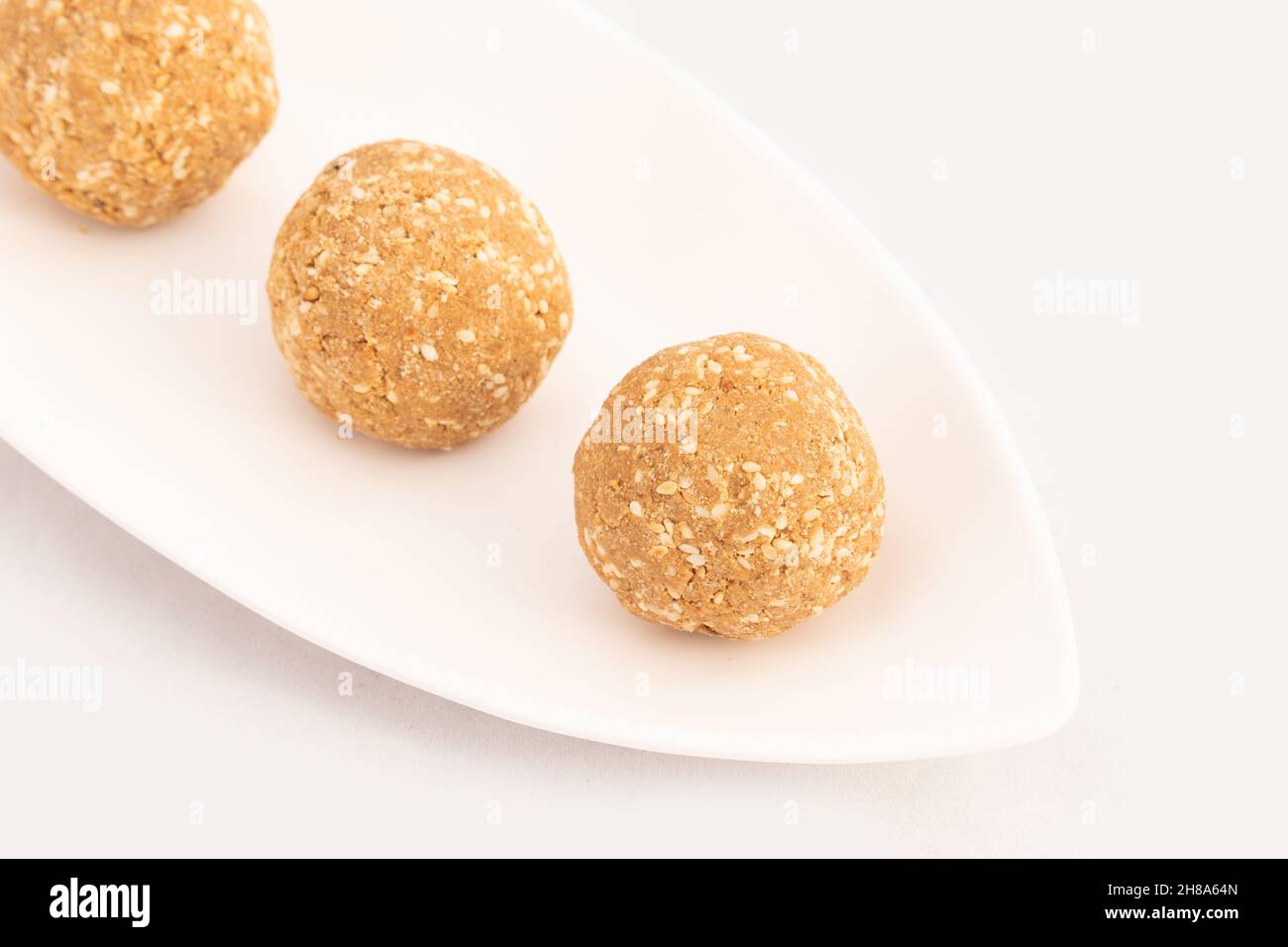 Le Mithai indien connu sous le nom de Tilgul Ladoo, Gajak Laddu, Gajjak Laddoo, Gazak ou Gachak est fait de graines de sésame Til, Gur ou Gard mélangé avec le Mugfali rôti, K Banque D'Images