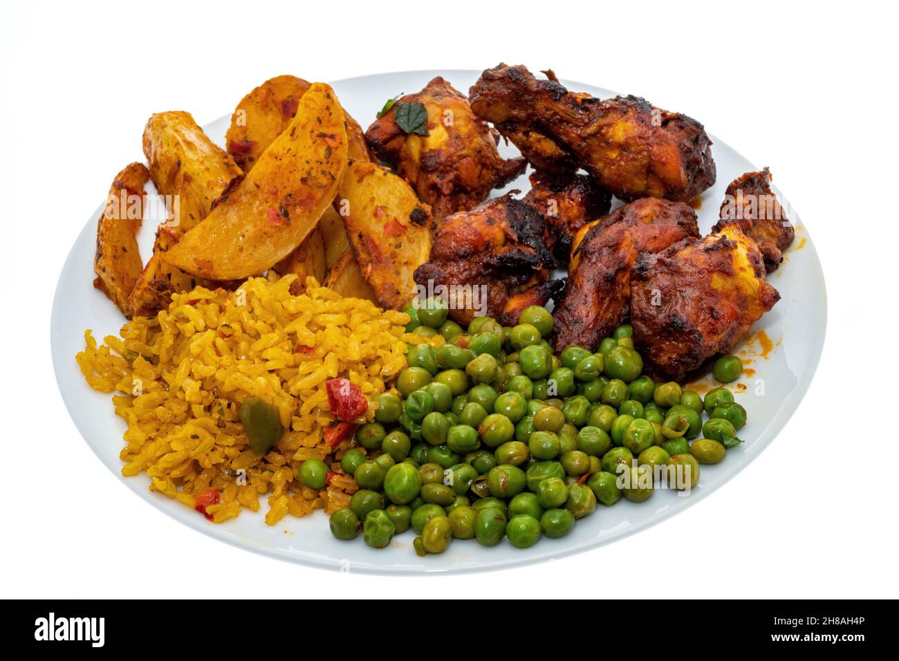 Repas des ailes de poulet péri-Peri avec des quartiers épicés, des pois et du riz - fond blanc Banque D'Images