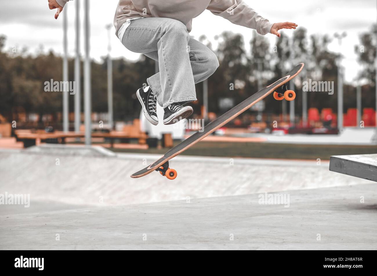 Jambes et planche à roulettes dans l'air au moment du saut Banque D'Images