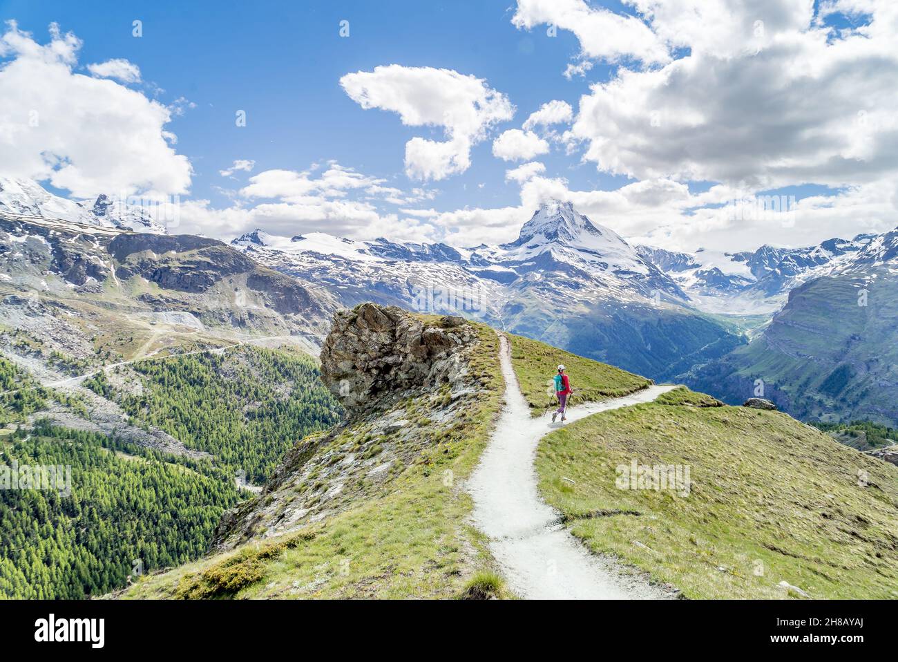 Randonneur sur un sentier en choisissant un chemin sur un autre dans un beau paysage de montagne, comme une décision métaphorique Banque D'Images