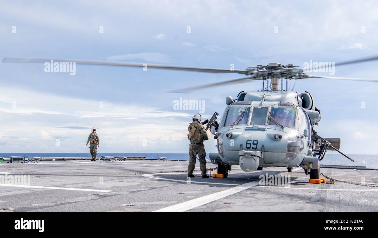 211126-N-PH222-1559 MER DES PHILIPPINES (NOV26, 2021) les marins effectuent une inspection visuelle finale d'un hélicoptère MH-60S Sea Hawk attaché aux « Blackjacks » de l'Escadron de combat de la mer (HSC) 21, sur le pont de vol à bord du navire de combat littoral de type Independence-variant USS Charleston (LCS 18), avant les opérations de vol courantes.Charleston, qui fait partie du Destroyer Squadron (DESRON) 7, est en cours de déploiement dans la zone d'exploitation de la 7e flotte américaine afin d'améliorer l'interopérabilité avec ses partenaires et de servir de force d'intervention en appui à une région Indo-Pacifique libre et ouverte.(É.-U.Bleu marine photo par Banque D'Images