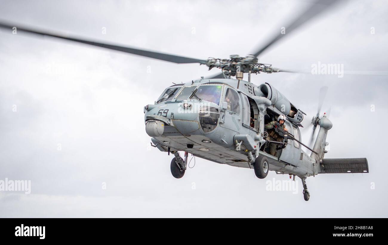 211126-N-PH222-1624 MER DES PHILIPPINES (NOV26, 2021) un hélicoptère MH-60S Sea Hawk attaché aux « Blackjacks » de l'Escadron de combat de la mer (HSC) 21, effectue une manœuvre de vol pendant les opérations de vol à bord du navire de combat littoral Independence-USS Charleston (LCS 18).Charleston, qui fait partie du Destroyer Squadron (DESRON) 7, est en cours de déploiement dans la zone d'exploitation de la 7e flotte américaine afin d'améliorer l'interopérabilité avec ses partenaires et de servir de force d'intervention en appui à une région Indo-Pacifique libre et ouverte.(É.-U.Photo de la marine par le spécialiste des communications de masse 2e classe Ryan M. Banque D'Images
