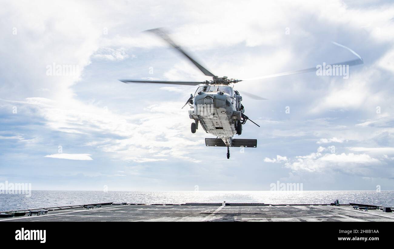 211126-N-PH222-1596 MER DES PHILIPPINES (NOV26, 2021)Un hélicoptère MH-60S Sea Hawk attaché aux « Blackjacks » de l'Escadron de combat de la mer (HSC) 21, effectue une manœuvre de vol au-dessus du pont de vol à bord du navire de combat littoral variante Independence USS Charleston (LCS 18), au cours des opérations de vol de routine.Charleston, qui fait partie du Destroyer Squadron (DESRON) 7, est en cours de déploiement dans la zone d'exploitation de la 7e flotte américaine afin d'améliorer l'interopérabilité avec ses partenaires et de servir de force d'intervention en appui à une région Indo-Pacifique libre et ouverte.(É.-U.Navy photo par Mass Communicat Banque D'Images