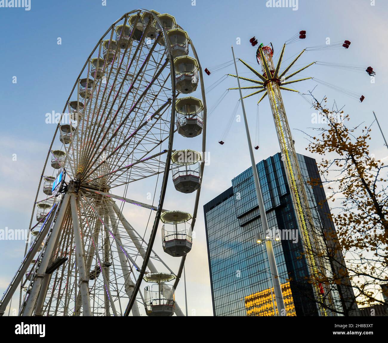 Grande roue et parc d'expositions à proximité de Noël, l'après-midi d'hiver ensoleillé, avec ciel bleu et bâtiments modernes, à côté de la nouvelle bibliothèque de Birmingham. Banque D'Images