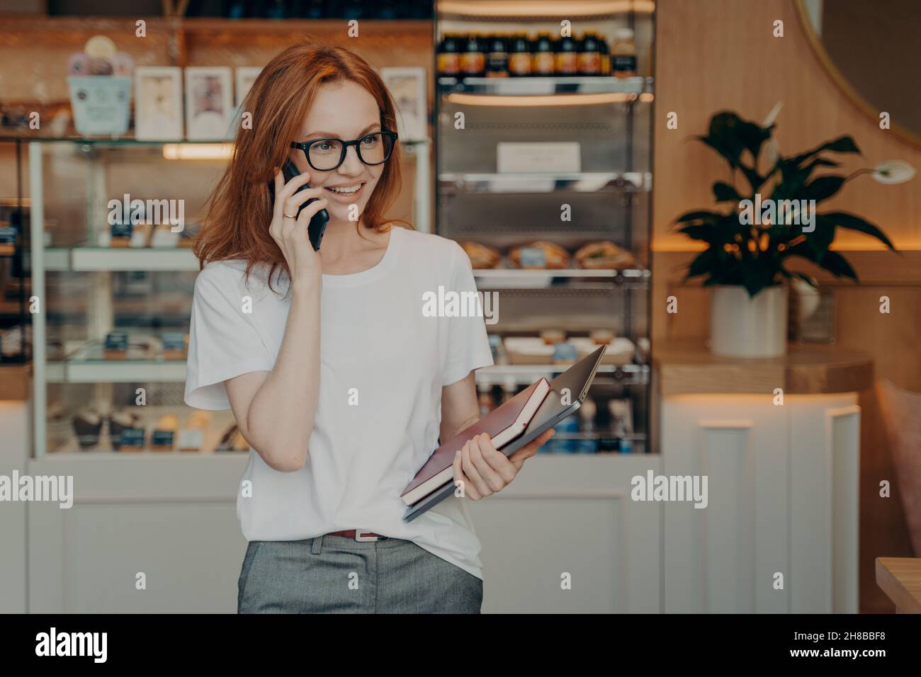 Sourire redhead jeune femme a la conversation téléphonique aime les discussions positives Banque D'Images