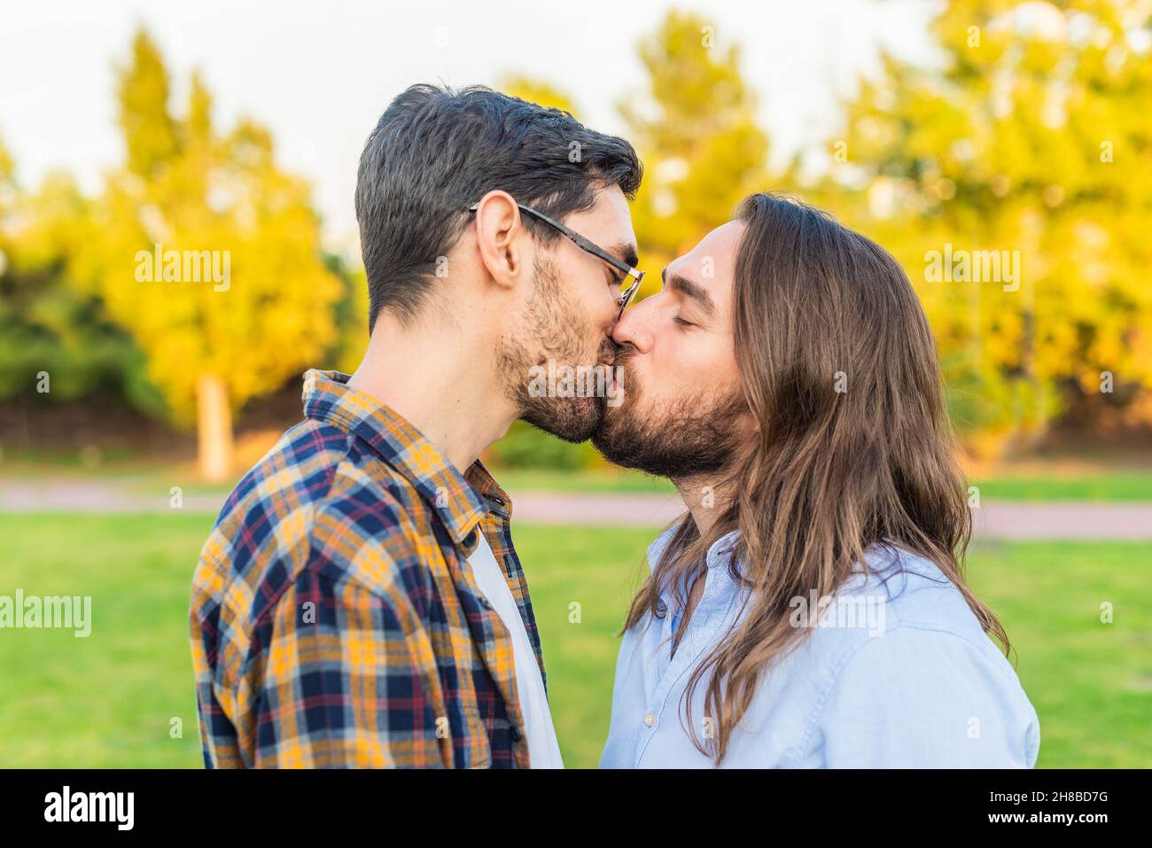 Un jeune couple gay masculin s'embrassant dans le parc. Banque D'Images
