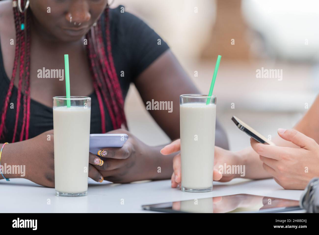 Vue rapprochée de deux verres de milk-shakes sur la table ivre par deux amis en plein air Banque D'Images
