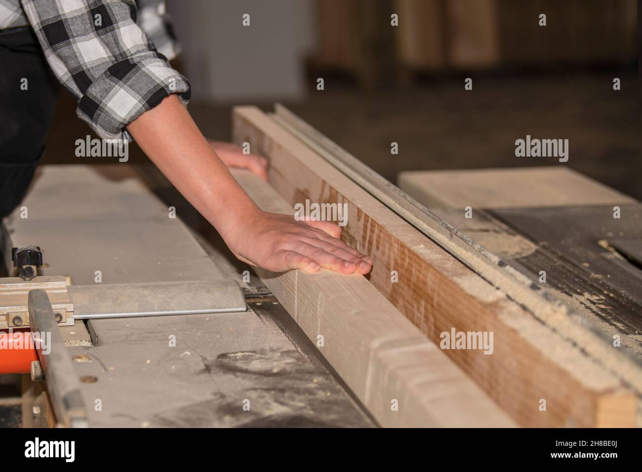 Femme travaillant sur des machines à travailler le bois dans un atelier de menuiserie Banque D'Images