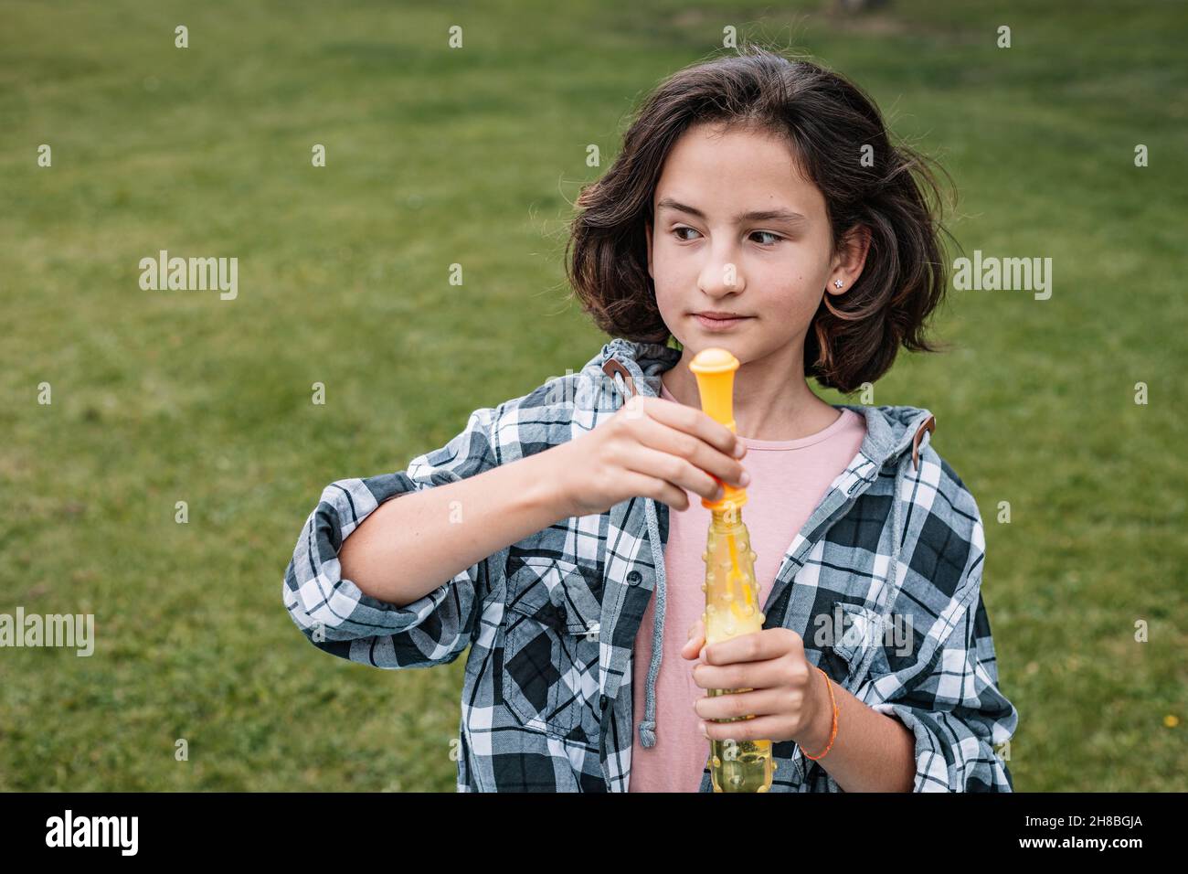 Portrait d'une jolie fille brune s'amusant dans un parc d'été.Attrayante fille d'école de race blanche avec des bulles de savon.Bonne enfance. Banque D'Images