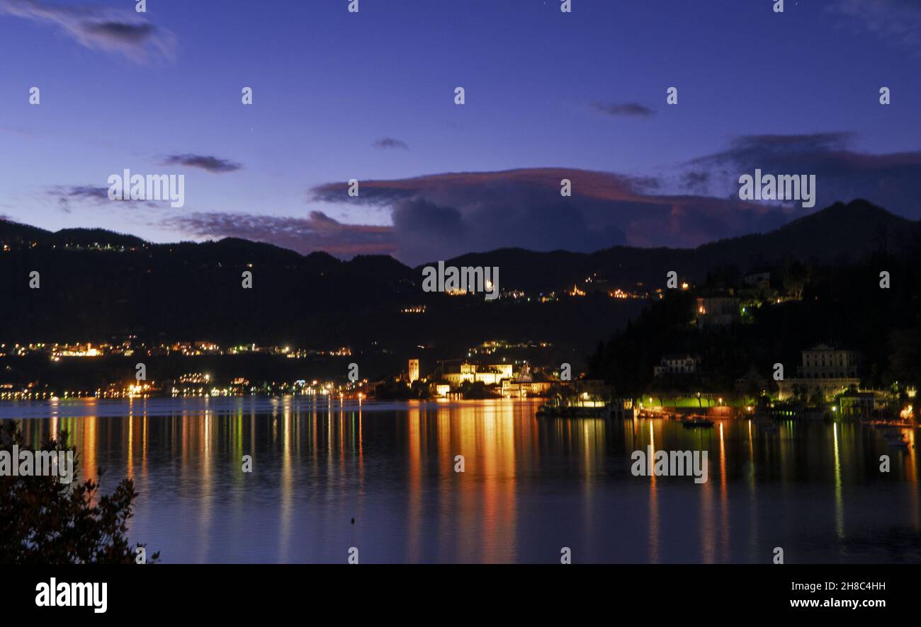 Lumières sur le lac à l'heure bleue.Orta lac, Piémont, Italie. Banque D'Images