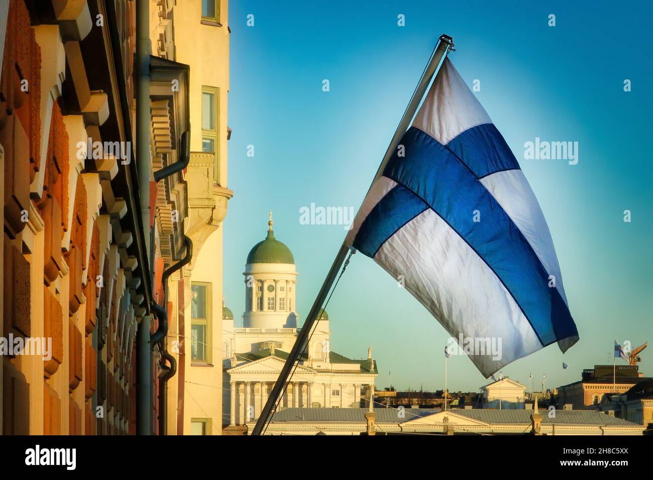 Drapeau national de la Finlande dans le centre d'Helsinki avec cathédrale d'Helsinki et ciel bleu en arrière-plan.Novembre 2021. Banque D'Images