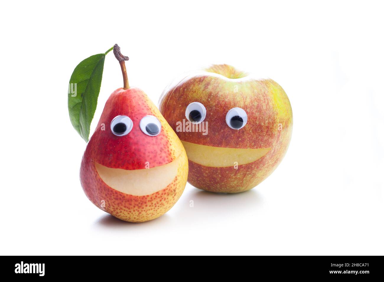 Une pomme souriante et une poire souriante isolée sur fond blanc Banque D'Images