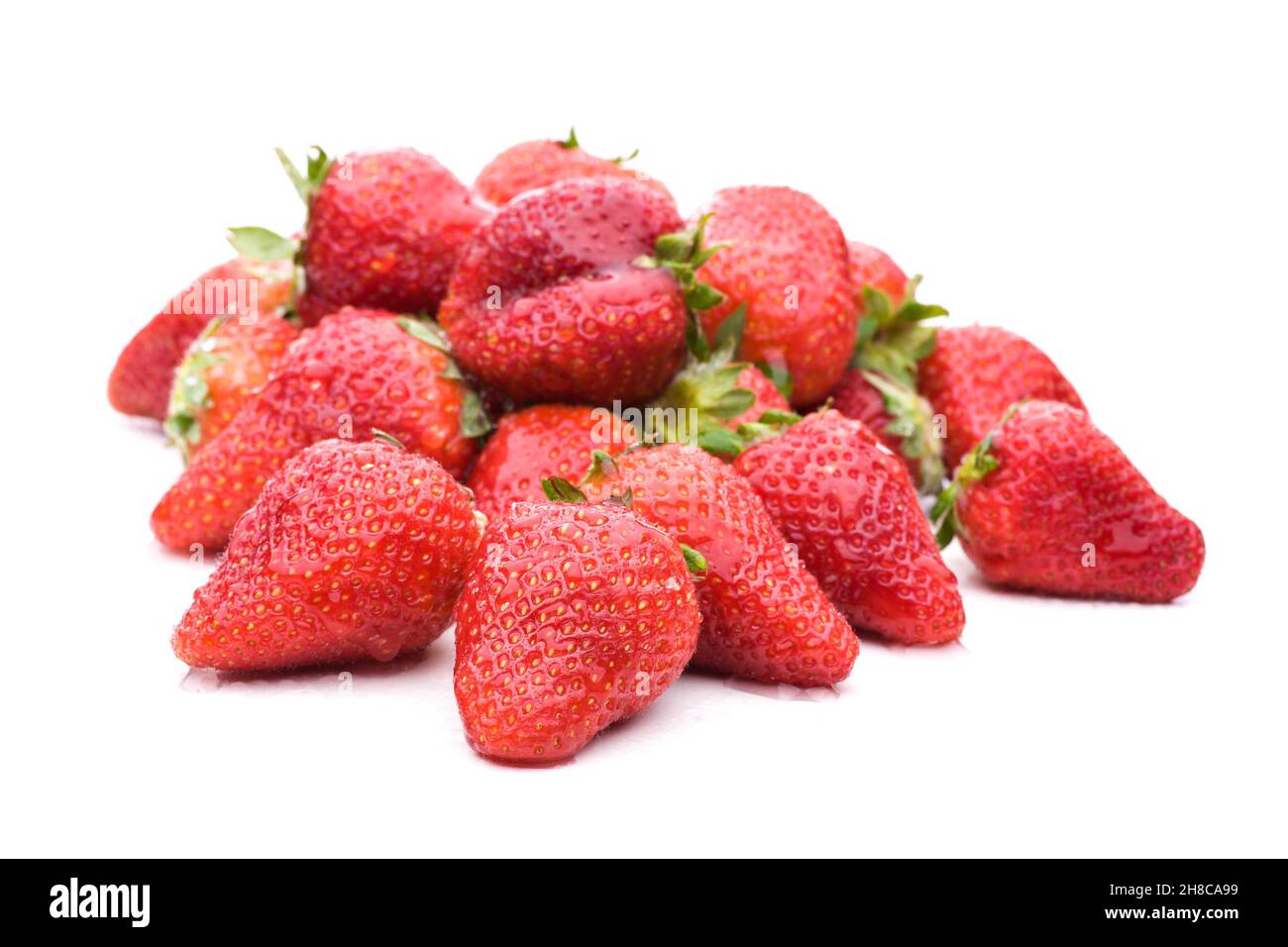 Beaucoup de fraises rouges dans un tas isolé sur fond blanc Banque D'Images