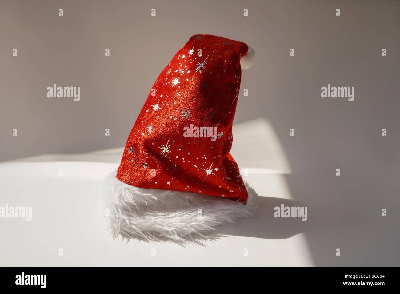 Chapeau de père Noël rouge sur fond blanc.Concept de style de vie de Noël et de nouvel an.Jour ensoleillé. Banque D'Images