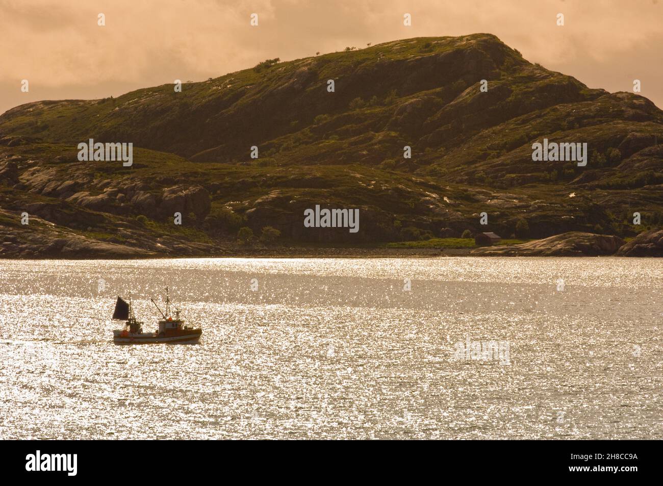 Bateau de pêche au large de la côte nord d'Uthaug dans la lumière du soir, Norvège, Trondelag, Uthaug Banque D'Images