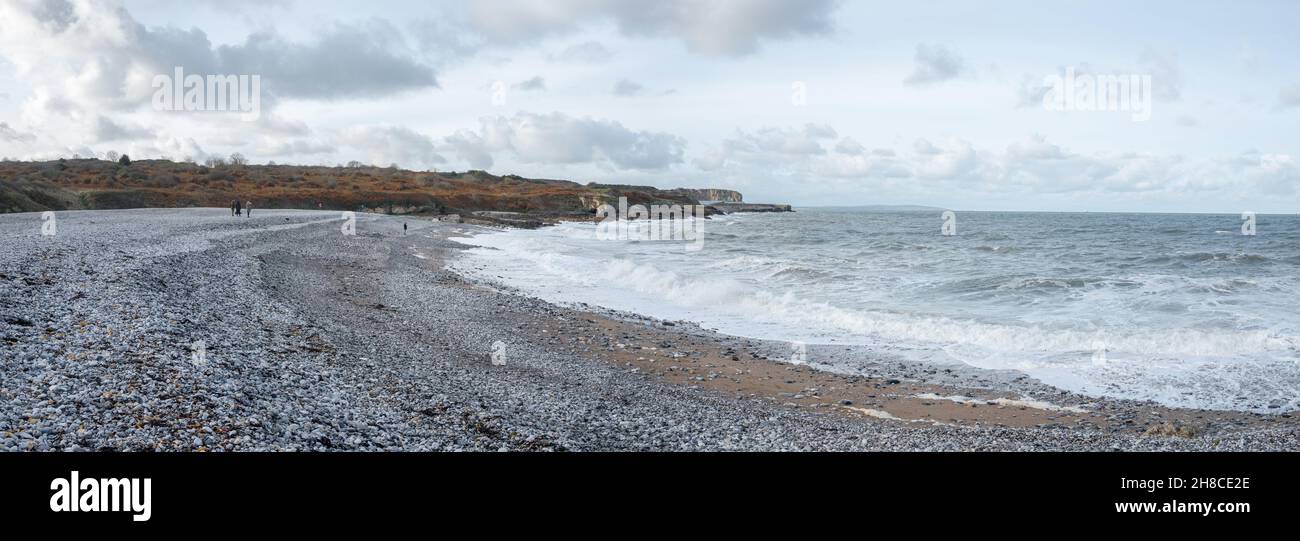Famille en train de faire une promenade sur la plage de galets de Penmon, Anglesey, pays de Galles Banque D'Images