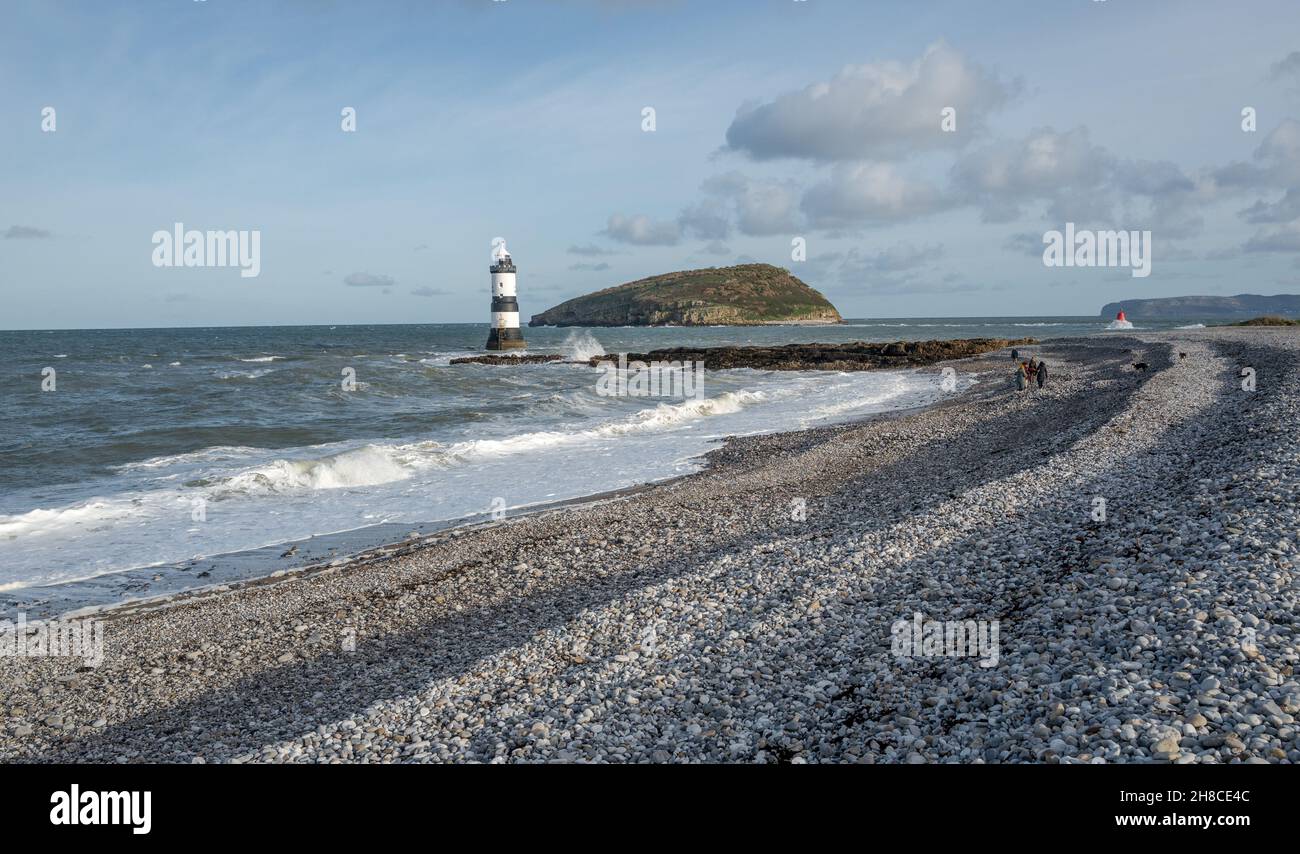 Famille en train de faire une promenade sur la plage de galets de Penmon, Anglesey, pays de Galles Banque D'Images